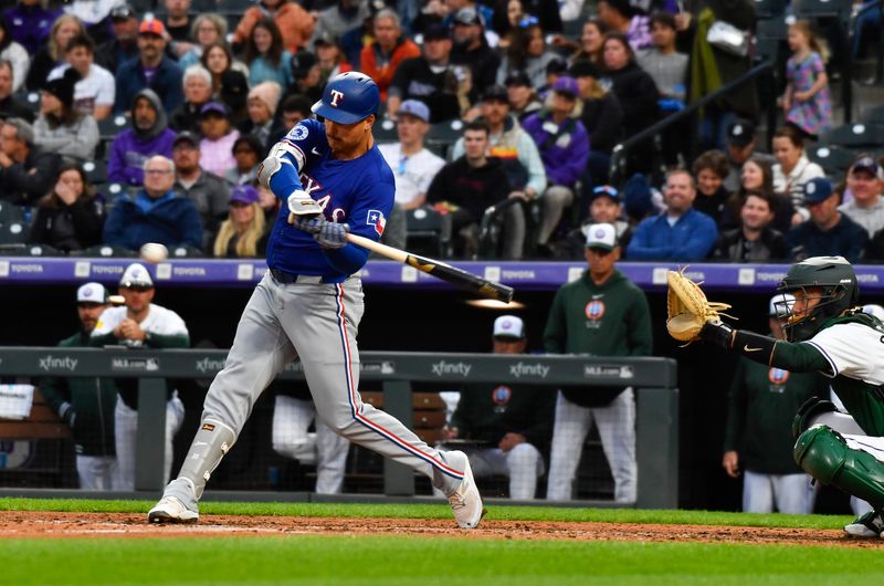 May 11, 2024; Denver, Colorado, USA;  Texas Rangers first base Nathaniel Lowe (30) hits a single against the Colorado Rockies during the fifth inning at Coors Field. Mandatory Credit: John Leyba-USA TODAY Sports