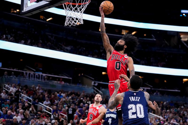 ORLANDO, FLORIDA - APRIL 07: Coby White #0 of the Chicago Bulls goes up for a shot against Markelle Fultz #20 of the Orlando Magic during the third quarter at Kia Center on April 07, 2024 in Orlando, Florida. NOTE TO USER: User expressly acknowledges and agrees that, by downloading and or using this photograph, User is consenting to the terms and conditions of the Getty Images License Agreement. (Photo by Rich Storry/Getty Images)