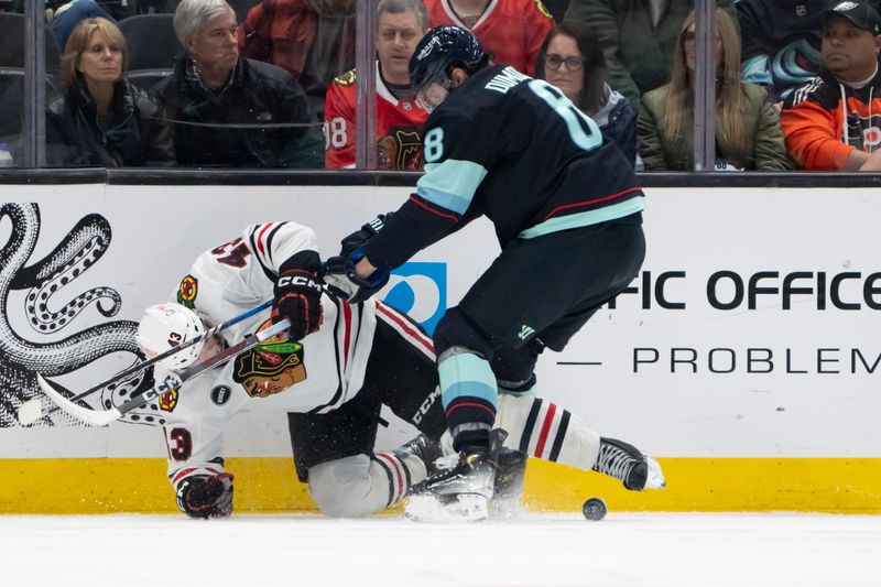 Jan 24, 2024; Seattle, Washington, USA; Chicago Blackhawks forward Colin Blackwell (43) and Seattle Kraken defenseman Brian Dumoulin (8) battle for the puck during the first period at Climate Pledge Arena. Mandatory Credit: Stephen Brashear-USA TODAY Sports