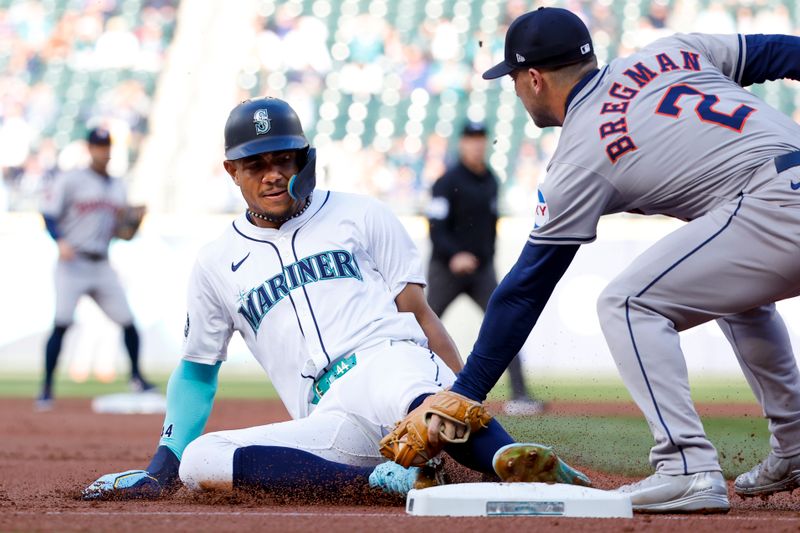 May 28, 2024; Seattle, Washington, USA; Houston Astros third baseman Alex Bregman (2) tags Seattle Mariners center fielder Julio Rodriguez (44) out on an attempt to advance form first base to third base on a hit by a teammate during the first inning at T-Mobile Park. Mandatory Credit: Joe Nicholson-USA TODAY Sports