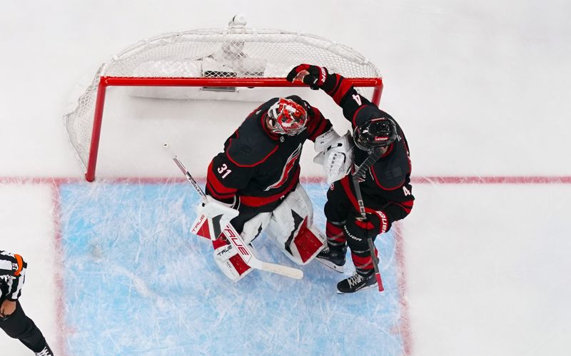 May 12, 2025; Raleigh, North Carolina, USA; Carolina Hurricanes goaltender Frederik Andersen (31) and defenseman Shayne Gostisbehere (4) celebrate their victory against the Washington Capitals in game four of the second round of the 2025 Stanley Cup Playoffs at Lenovo Center. Mandatory Credit: James Guillory-Imagn Images
