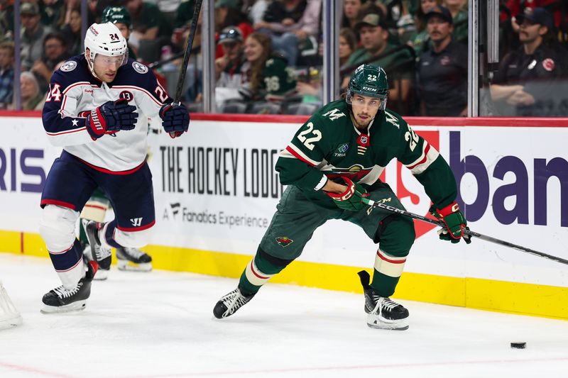 Oct 10, 2024; Saint Paul, Minnesota, USA; Minnesota Wild center Marat Khusnutdinov (22) skates with the puck as Columbus Blue Jackets right wing Mathieu Olivier (24) defends during the third period at Xcel Energy Center. Mandatory Credit: Matt Krohn-Imagn Images