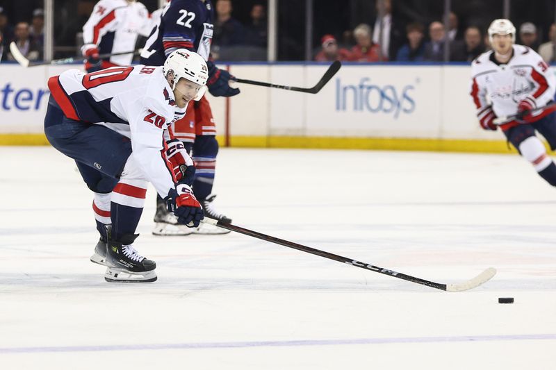Mar 5, 2025; New York, New York, USA;  Washington Capitals center Lars Eller (20) reaches for the puck in the first period against the New York Rangers at Madison Square Garden. Mandatory Credit: Wendell Cruz-Imagn Images