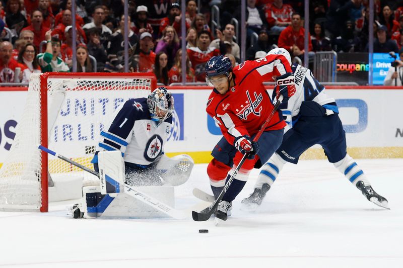 Nov 26, 2025; Washington, District of Columbia, USA; Washington Capitals right wing Justin Sourdif (34) prepares to shoot the puck on Winnipeg Jets goaltender Eric Comrie (1) during the first period at Capital One Arena. Mandatory Credit: Geoff Burke-Imagn Images