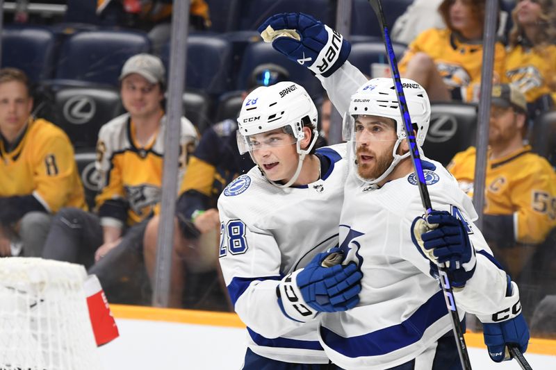 Sep 27, 2023; Nashville, Tennessee, USA; Tampa Bay Lightning forward Tyler Motte (64) celebrates with defenseman Jack Thompson (28) after scoring the game-winning goal in overtime against the Nashville Predators at Bridgestone Arena. Mandatory Credit: Christopher Hanewinckel-USA TODAY Sports