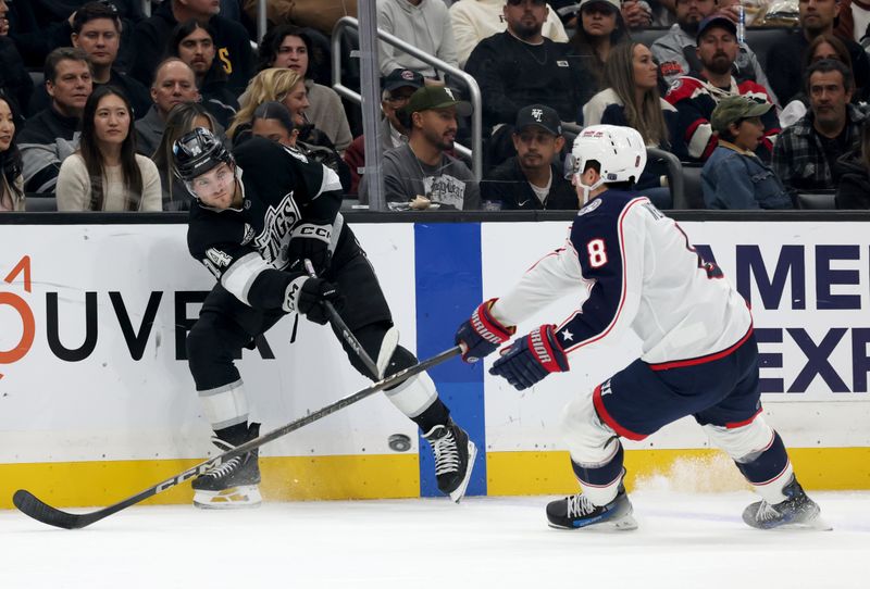 Nov 9, 2024; Los Angeles, California, USA; Los Angeles Kings right wing Alex Laferriere (14) passes against Columbus Blue Jackets defenseman Zach Werenski (8) during the second period at Crypto.com Arena. Mandatory Credit: Jason Parkhurst-Imagn Images