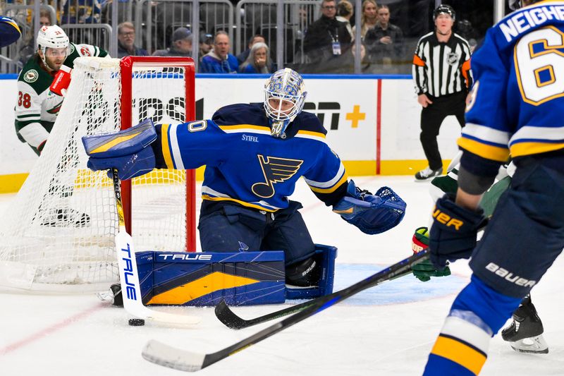 Nov 19, 2024; St. Louis, Missouri, USA;  St. Louis Blues goaltender Jordan Binnington (50) defends the net against the Minnesota Wild during the first period at Enterprise Center. Mandatory Credit: Jeff Curry-Imagn Images