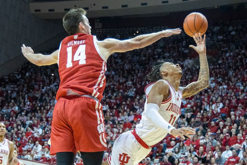 Jan 14, 2023; Bloomington, Indiana, USA; Indiana Hoosiers guard CJ Gunn (11) shoots the ball while Wisconsin Badgers forward Carter Gilmore (14) defends in the first half at Simon Skjodt Assembly Hall. Mandatory Credit: Trevor Ruszkowski-USA TODAY Sports