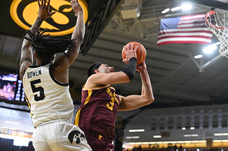 Feb 11, 2024; Iowa City, Iowa, USA; Minnesota Golden Gophers forward Dawson Garcia (3) goes to the basket as Iowa Hawkeyes guard Dasonte Bowen (5) defends during the first half at Carver-Hawkeye Arena. Mandatory Credit: Jeffrey Becker-USA TODAY Sports