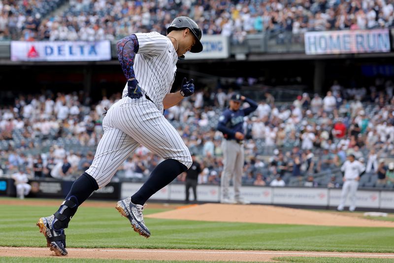 May 23, 2024; Bronx, New York, USA; New York Yankees designated hitter Giancarlo Stanton (27) rounds the bases after hitting a solo home run against Seattle Mariners starting pitcher Luis Castillo (58) during the second inning at Yankee Stadium. Mandatory Credit: Brad Penner-USA TODAY Sports