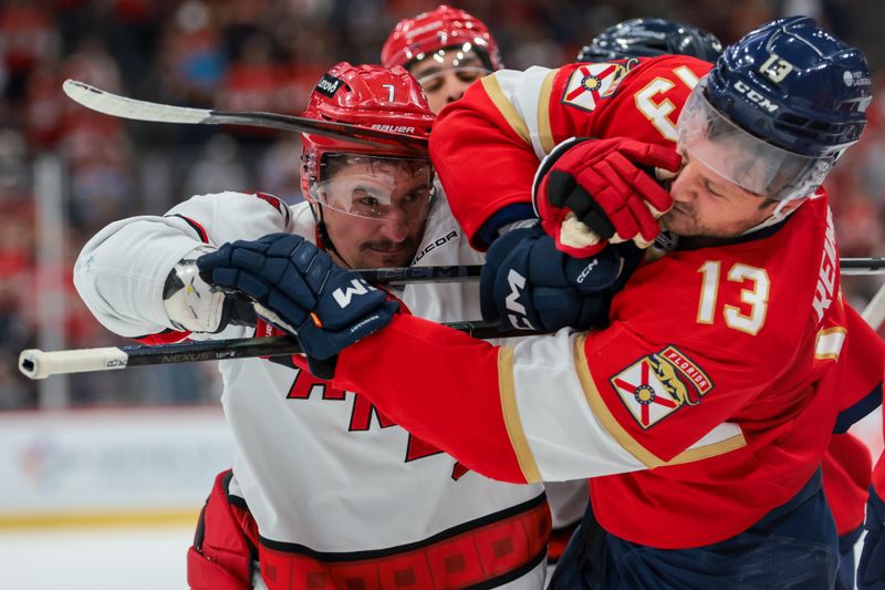 Nov 30, 2024; Sunrise, Florida, USA; Carolina Hurricanes defenseman Dmitry Orlov (7) hits Florida Panthers center Sam Reinhart (13) at the ned of the first period at Amerant Bank Arena. Mandatory Credit: Sam Navarro-Imagn Images