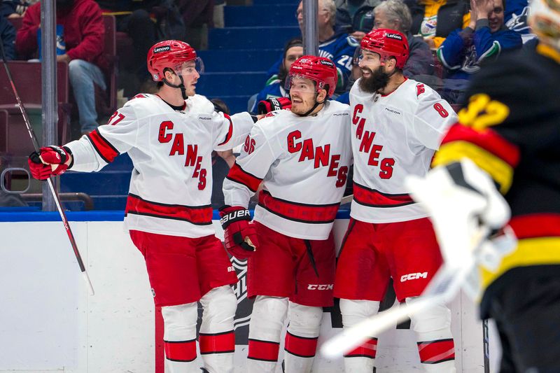 Oct 28, 2024; Vancouver, British Columbia, CAN; Carolina  Hurricanes forward Jack Roslovic (96) celebrates his goal with forward Andrei Svechnikov (37) and defenseman Brent Burns (8) against the Vancouver Canucks during the second period at Rogers Arena. Mandatory Credit: Bob Frid-Imagn Images