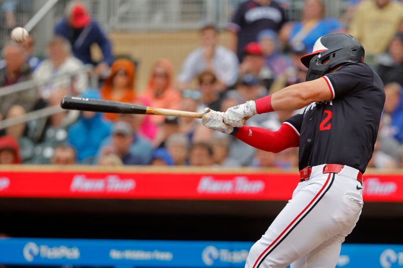 Jun 20, 2024; Minneapolis, Minnesota, USA; Minnesota Twins second baseman Kyle Farmer (12) hits an RBI double against the Tampa Bay Rays in the second inning at Target Field. Mandatory Credit: Bruce Kluckhohn-USA TODAY Sports