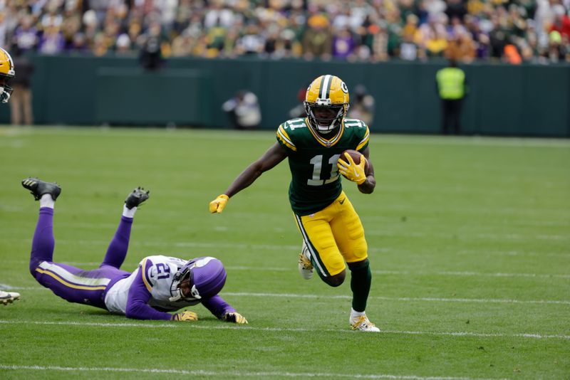 Green Bay Packers wide receiver Jayden Reed (11) tries to elude Minnesota Vikings cornerback Akayleb Evans (21) during an NFL football game Sunday, Oct. 29, 2023, in Green Bay, Wis. (AP Photo/Mike Roemer)