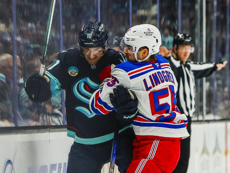 Nov 17, 2024; Seattle, Washington, USA; New York Rangers defenseman Ryan Lindgren (55) hits Seattle Kraken center Matty Beniers (10) against the boards during the third period at Climate Pledge Arena. Mandatory Credit: Joe Nicholson-Imagn Images