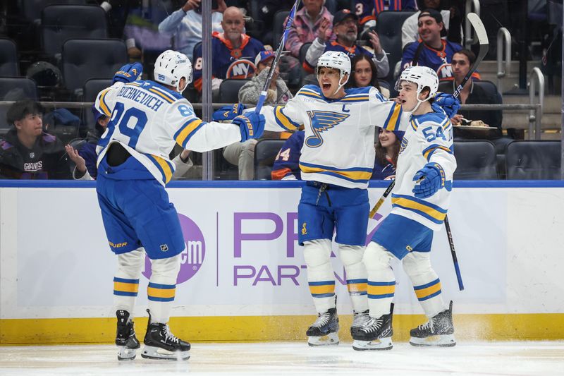 Nov 22, 2025; Elmont, New York, USA;  St. Louis Blues center Brayden Schenn (10) celebrates with left wing Pavel Buchnevich (89) and right wing Dalibor Dvorsky (54) after scoring a goal in the first period against the New York Islanders at UBS Arena. Mandatory Credit: Wendell Cruz-Imagn Images