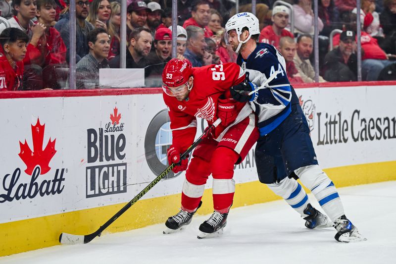 Oct 30, 2024; Detroit, Michigan, USA; Winnipeg Jets defenseman Josh Morrissey (44) checks Detroit Red Wings right wing Alex DeBrincat (93) during the second period at Little Caesars Arena. Mandatory Credit: Tim Fuller-Imagn Images