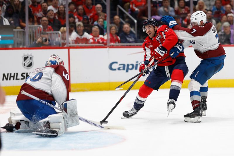 Nov 21, 2024; Washington, District of Columbia, USA; Washington Capitals right wing Tom Wilson (43) skates with the puck on Colorado Avalanche goaltender Alexandar Georgiev (40) as Avalanche defenseman Devon Toews (7) defends in the third period at Capital One Arena. Mandatory Credit: Geoff Burke-Imagn Images