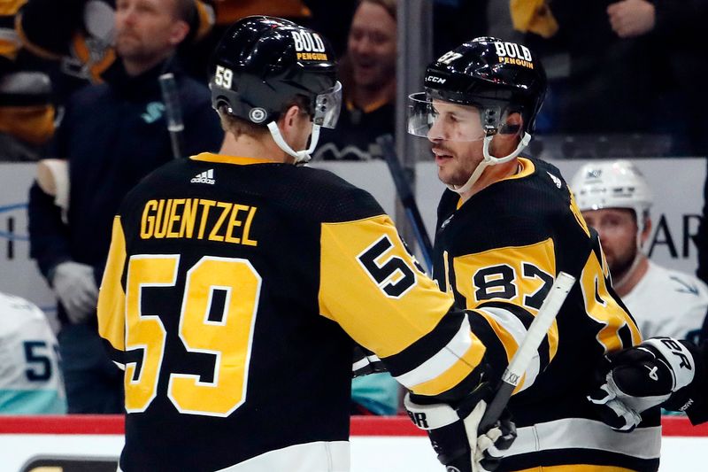 Jan 15, 2024; Pittsburgh, Pennsylvania, USA; Pittsburgh Penguins left wing Jake Guentzel (59) congratulates center Sidney Crosby (87) after Crosby scored an empty net goal to record his second goal of the game against the Seattle Kraken during the third period at PPG Paints Arena. Mandatory Credit: Charles LeClaire-USA TODAY Sports