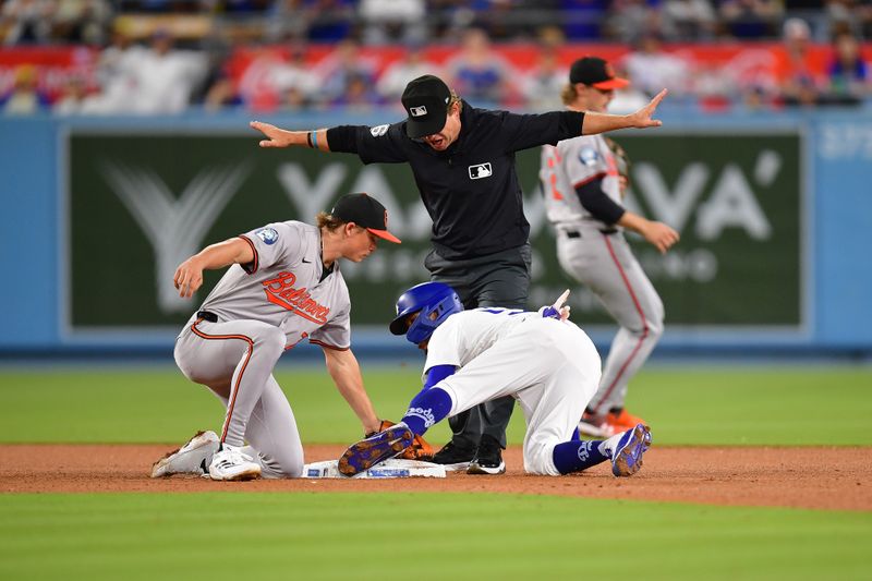 Aug 27, 2024; Los Angeles, California, USA; Los Angeles Dodgers right fielder Mookie Betts (50) steals second against Baltimore Orioles second baseman Jackson Holliday (7) during the seventh inning at Dodger Stadium. Mandatory Credit: Gary A. Vasquez-USA TODAY Sports