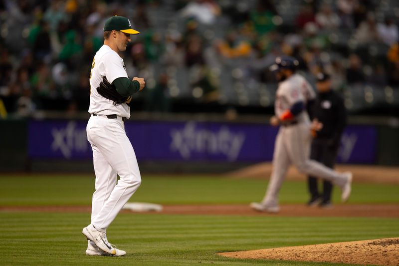 May 24, 2024; Oakland, California, USA; Oakland Athletics starting pitcher Ross Stripling (36) rubs up a new baseball while Houston Astros center fielder Jake Meyers runs out a three-run home run during the fourth inning at Oakland-Alameda County Coliseum. Mandatory Credit: D. Ross Cameron-USA TODAY Sports