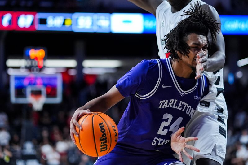Dec 1, 2025; Cincinnati, Ohio, USA;  Tarleton State Texans forward Ocypher Owens (24) drives to the basket against Cincinnati Bearcats center Moustapha Thiam (52) in the second half at Fifth Third Arena. Mandatory Credit: Aaron Doster-Imagn Images