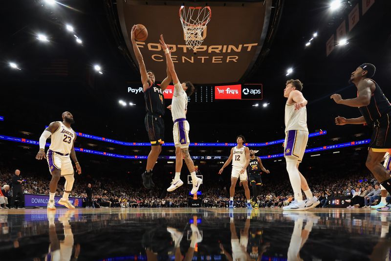 PHOENIX, ARIZONA - NOVEMBER 26: Oso Ighodaro #4 of the Phoenix Suns attempts a shot against Max Christie #12 of the Los Angeles Lakers during the first half of the Emirates NBA Cup game at Footprint Center on November 26, 2024 in Phoenix, Arizona. NOTE TO USER: User expressly acknowledges and agrees that, by downloading and/or using this photograph, user is consenting to the terms and conditions of the Getty Images License Agreement. (Photo by Christian Petersen/Getty Images)