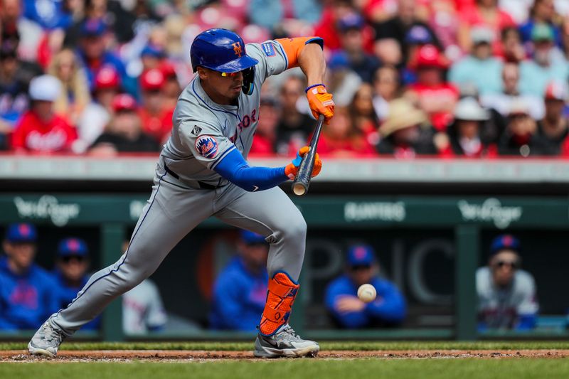 Apr 7, 2024; Cincinnati, Ohio, USA; New York Mets right fielder Tyrone Taylor (15) bunts a single against the Cincinnati Reds in the second inning at Great American Ball Park. Mandatory Credit: Katie Stratman-USA TODAY Sports