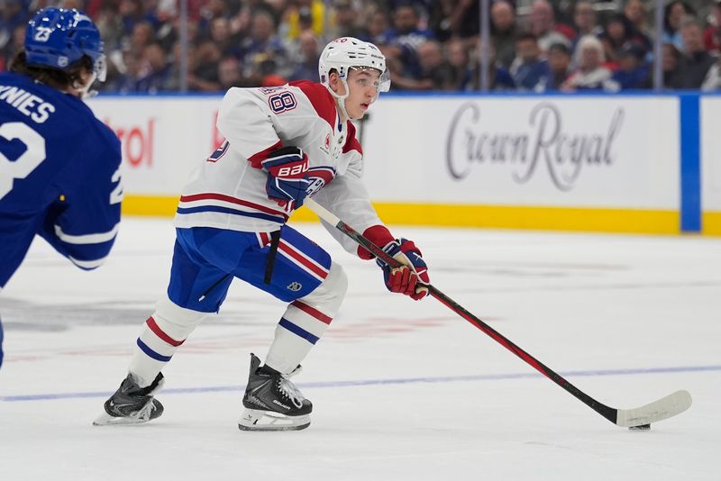 Sep 27, 2025; Toronto, Ontario, CAN; defenseman Lane Hutson (48) carries the puck against the Toronto Maple Leafs during the second period at Scotiabank Arena. Mandatory Credit: John E. Sokolowski-Imagn Images