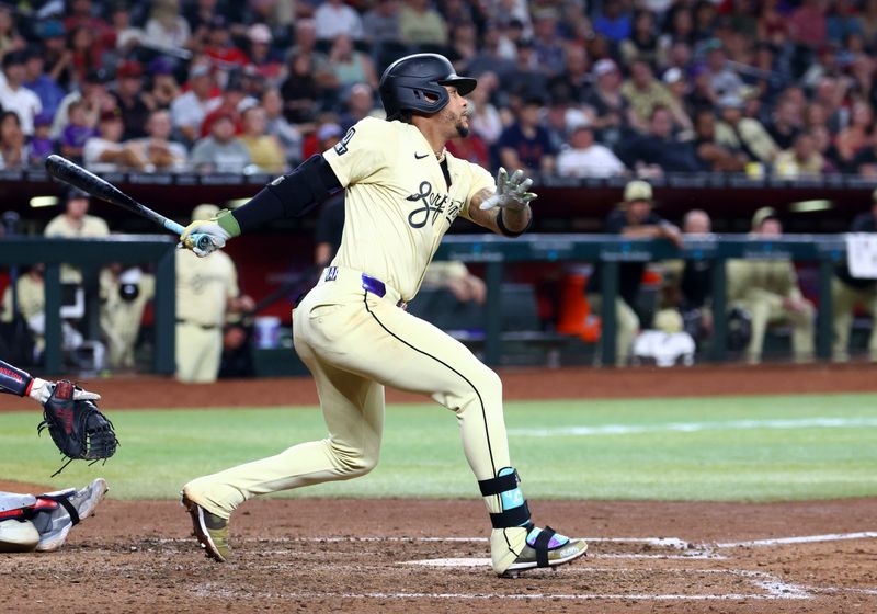 Jun 25, 2024; Phoenix, Arizona, USA; Arizona Diamondbacks infielder Ketel Marte hits an RBI single in the seventh inning against the Minnesota Twins at Chase Field. Mandatory Credit: Mark J. Rebilas-USA TODAY Sports