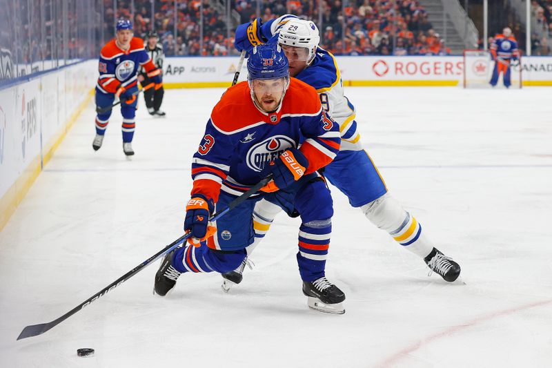 Jan 25, 2025; Edmonton, Alberta, CAN; Edmonton Oilers forward Victor Arvidsson (33) protects the puck from Buffalo Sabres forward Beck Malenstyn (29) during the first period at Rogers Place. Mandatory Credit: Perry Nelson-Imagn Images