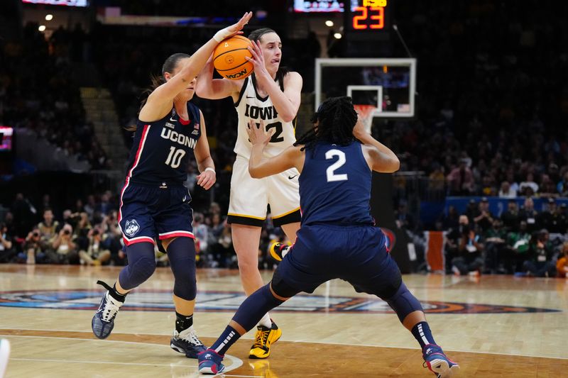Apr 5, 2024; Cleveland, OH, USA; Iowa Hawkeyes guard Caitlin Clark (22) passes against Connecticut Huskies guard Nika Muhl (10) and guard KK Arnold (2) in the first quarter in the semifinals of the Final Four of the womens 2024 NCAA Tournament at Rocket Mortgage FieldHouse. Mandatory Credit: Kirby Lee-USA TODAY Sports