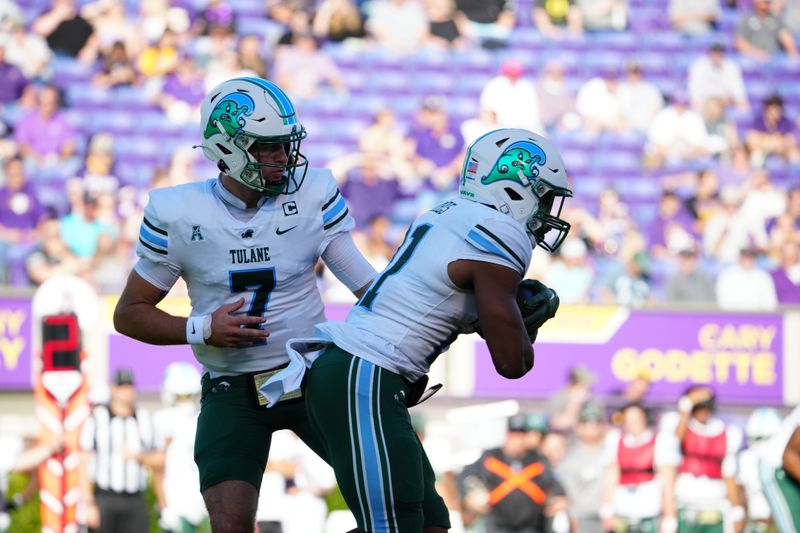 Nov 4, 2023; Greenville, North Carolina, USA; Tulane Green Wave quarterback Michael Pratt (7) hands the ball off to running back Makhi Hughes (21) against the East Carolina Pirates during the first half at Dowdy-Ficklen Stadium. Mandatory Credit: James Guillory-USA TODAY Sports