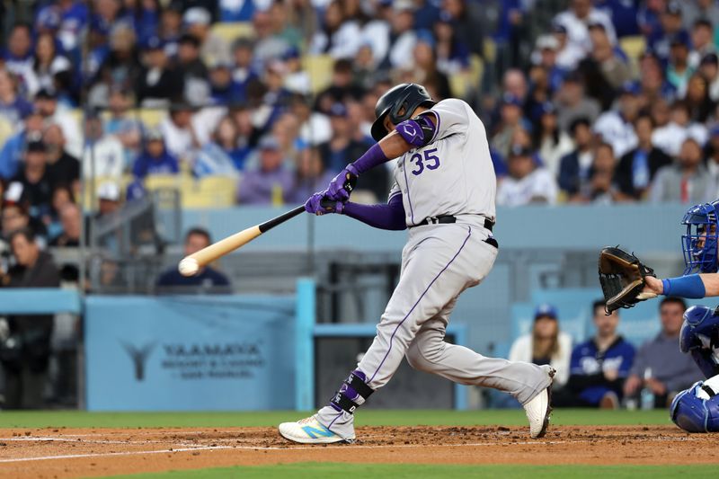 Jun 1, 2024; Los Angeles, California, USA;  Colorado Rockies catcher Elias Diaz (35) hits a single during the third inning against the Los Angeles Dodgers at Dodger Stadium. Mandatory Credit: Kiyoshi Mio-USA TODAY Sports