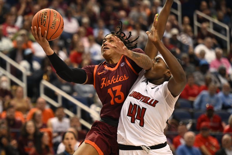 Mar 5, 2023; Greensboro, NC, USA; Virginia Tech Hokies forward Taylor Soule (13) shoots past Louisville Cardinals forward Olivia Cochran (44) during the second half at Greensboro Coliseum. Mandatory Credit: William Howard-USA TODAY Sports