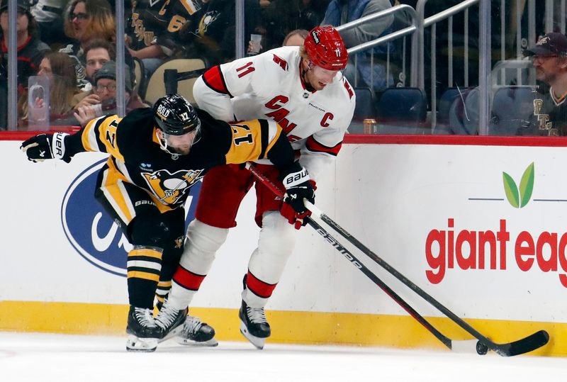 Oct 18, 2024; Pittsburgh, Pennsylvania, USA;  Pittsburgh Penguins right wing Bryan Rust (17) and Carolina Hurricanes center Jordan Staal (11) battle to control the puck during the second period at PPG Paints Arena. Mandatory Credit: Charles LeClaire-Imagn Images