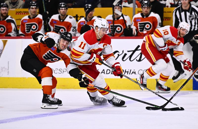 Jan 6, 2024; Philadelphia, Pennsylvania, USA; Calgary Flames center Mikael Backlund (11) pushes the puck past Philadelphia Flyers right wing Cam Atkinson (89) in the first period at Wells Fargo Center. Mandatory Credit: Kyle Ross-USA TODAY Sports