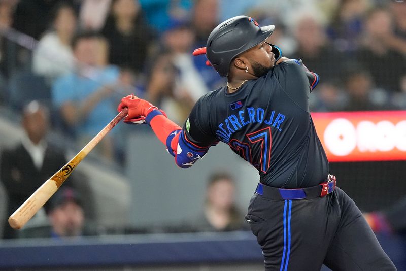 Sep 13, 2024; Toronto, Ontario, CAN; Toronto Blue Jays third baseman Vladimir Guerrero Jr. (27) hits a double against the St. Louis Cardinals during the fourth inning at Rogers Centre. Mandatory Credit: John E. Sokolowski-Imagn Images