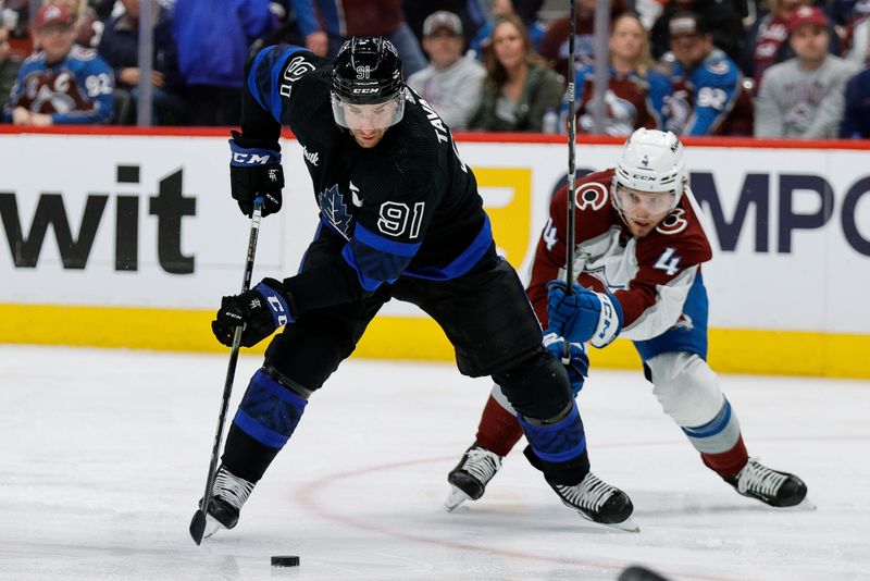 Feb 24, 2024; Denver, Colorado, USA; Toronto Maple Leafs center John Tavares (91) controls the puck ahead of Colorado Avalanche defenseman Bowen Byram (4) in the third period at Ball Arena. Mandatory Credit: Isaiah J. Downing-USA TODAY Sports