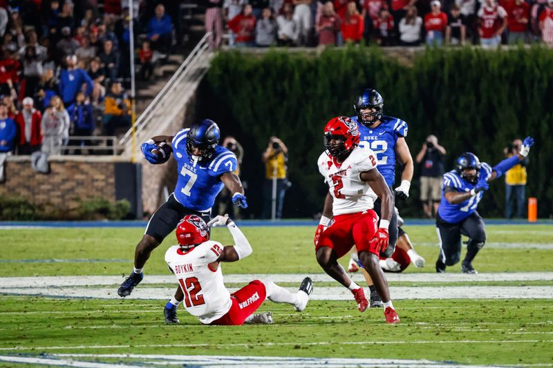 Oct 14, 2023; Durham, North Carolina, USA; Duke Blue Devils running back Jordan Waters (7) runs with the football  wile North Carolina State Wolfpack defensive back Devan Boykin (12) attempts to tackle him during the first half of the game against at Wallace Wade Stadium. Mandatory Credit: Jaylynn Nash-USA TODAY Sports