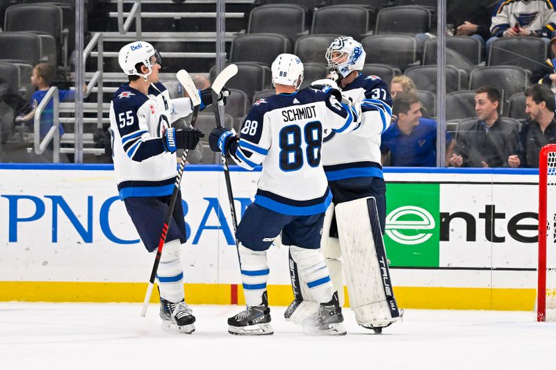 Nov 7, 2023; St. Louis, Missouri, USA;  Winnipeg Jets goaltender Connor Hellebuyck (37) celebrates with center Mark Scheifele (55) and defenseman Nate Schmidt (88) after the Jets defeated the St. Louis Blues at Enterprise Center. Mandatory Credit: Jeff Curry-USA TODAY Sports