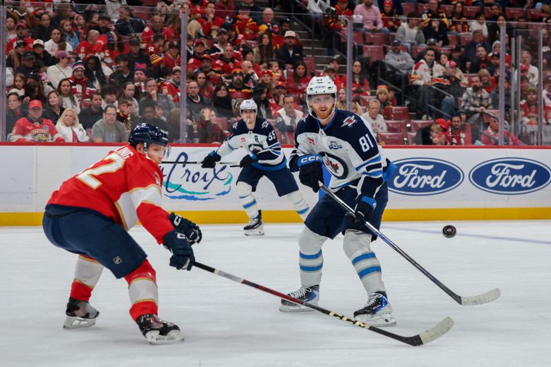 Jan 31, 2026; Sunrise, Florida, USA; Winnipeg Jets left wing Kyle Connor (81) passes the puck as Florida Panthers defenseman Gustav Forsling (42) defends during the first period at Amerant Bank Arena. Mandatory Credit: Sam Navarro-Imagn Images