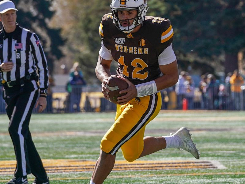 Oct 26, 2019; Laramie, WY, USA; Wyoming Cowboys quarterback Sean Chambers (12) scores a touchdown during the first quarter against the Nevada Wolf Pack at Jonah Field War Memorial Stadium. Mandatory Credit: Troy Babbitt-USA TODAY Sports