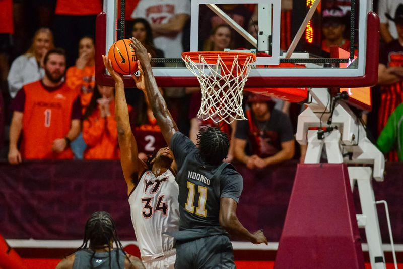 Jan 27, 2024; Blacksburg, Virginia, USA; Georgia Tech Yellow Jackets forward Baye Ndongo (11) blocks Virginia Tech Hokies forward Mylyjael Poteat (34) during the first half at Cassell Coliseum. Mandatory Credit: Brian Bishop-USA TODAY Sports