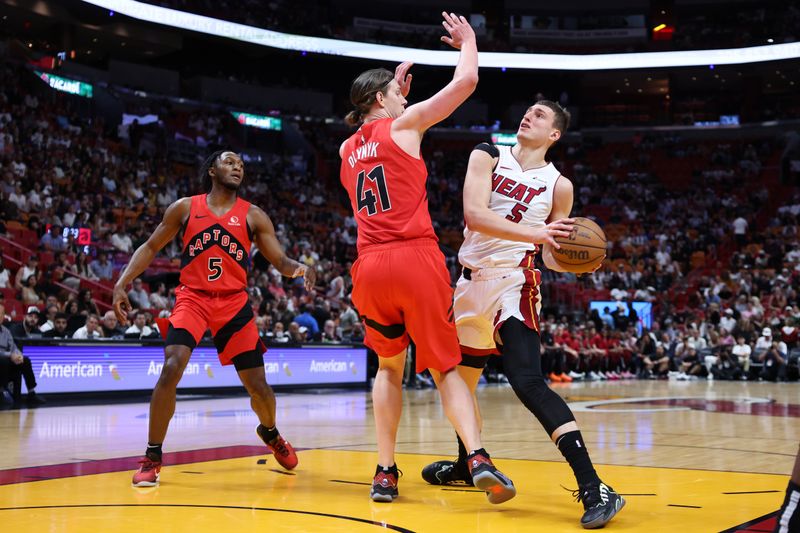 MIAMI, FLORIDA - APRIL 12: Nikola Jovic #5 of the Miami Heat drives to the basket against Kelly Olynyk #41 of the Toronto Raptors during the first quarter of the game at Kaseya Center on April 12, 2024 in Miami, Florida. NOTE TO USER: User expressly acknowledges and agrees that, by downloading and or using this photograph, User is consenting to the terms and conditions of the Getty Images License Agreement. (Photo by Megan Briggs/Getty Images)