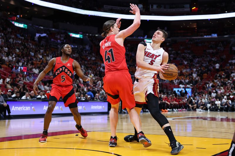 MIAMI, FLORIDA - APRIL 12: Nikola Jovic #5 of the Miami Heat drives to the basket against Kelly Olynyk #41 of the Toronto Raptors during the first quarter of the game at Kaseya Center on April 12, 2024 in Miami, Florida. NOTE TO USER: User expressly acknowledges and agrees that, by downloading and or using this photograph, User is consenting to the terms and conditions of the Getty Images License Agreement. (Photo by Megan Briggs/Getty Images)