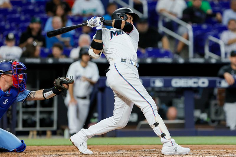 Jun 21, 2023; Miami, Florida, USA; Miami Marlins second baseman Luis Arraez (3) hits a single against the Toronto Blue Jays during the third inning at loanDepot Park. Mandatory Credit: Sam Navarro-USA TODAY Sports