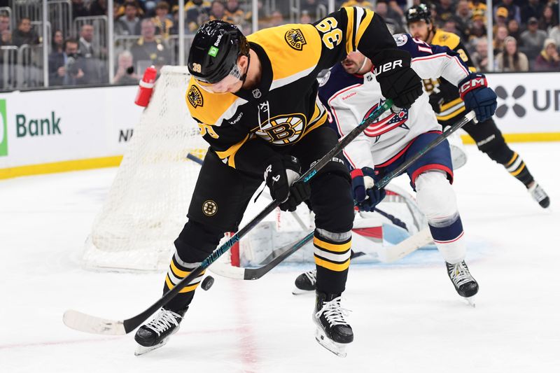 Nov 18, 2024; Boston, Massachusetts, USA;  Boston Bruins center Morgan Geekie (39) looks for the puck while Columbus Blue Jackets defenseman Dante Fabbro (15) defends during the first period at TD Garden. Mandatory Credit: Bob DeChiara-Imagn Images