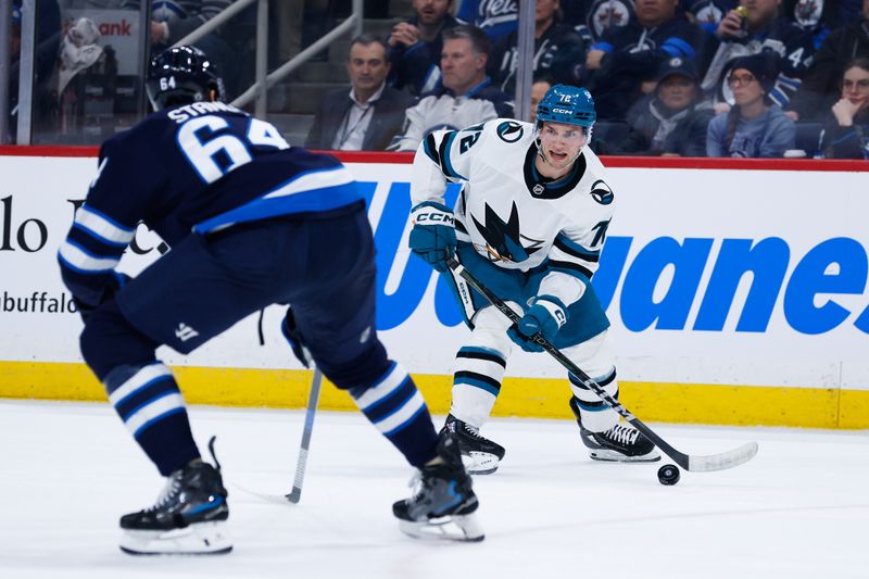 Feb 24, 2025; Winnipeg, Manitoba, CAN;  San Jose Sharks forward William Eklund (72) skates in on Winnipeg Jets defenseman Logan Stanley (64) during the first period at Canada Life Centre. Mandatory Credit: Terrence Lee-Imagn Images