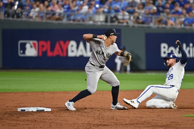 Oct 9, 2024; Kansas City, Missouri, USA; New York Yankees shortstop Anthony Volpe (11) turns double play against Kansas City Royals outfielder Kyle Isbel (28) in the third inning during game three of the NLDS for the 2024 MLB Playoffs at Kauffman Stadium. Mandatory Credit: Peter Aiken-Imagn Images